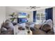 Comfortable living room with gray sofas, large TV and ceiling fan at 5550 Eyerly Ter, Port Charlotte, FL 33981