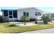 Landscaped mobile home with covered porch and mature plants at 563 Portside Dr, North Port, FL 34287
