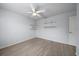 Bedroom with wood-look floors, ceiling fan, and built-in shelves at 5891 Madison Rd, Venice, FL 34293
