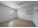 Bedroom with wood-look floors, ceiling fan, and built-in shelves at 5891 Madison Rd, Venice, FL 34293