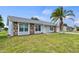House with gray exterior, stone accents, and a palm tree in the front yard at 6232 Drucker Cir, Port Charlotte, FL 33981