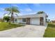 Front view of a single story home with a large driveway at 6232 Drucker Cir, Port Charlotte, FL 33981