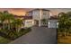 Two-story house with gray walls, tile roof, and a three-car garage at 7484 Ripetta St, Sarasota, FL 34240