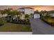 Two-story house with gray walls, tile roof, and a three-car garage at 7484 Ripetta St, Sarasota, FL 34240