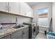 Laundry room boasts modern washer, dryer, and ample storage at 7484 Ripetta St, Sarasota, FL 34240
