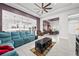 Open concept living room, showcasing a teal sectional and views into dining & kitchen areas at 7484 Ripetta St, Sarasota, FL 34240