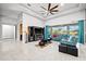 Spacious living room with teal sectional sofa, large TV, and access to backyard at 7484 Ripetta St, Sarasota, FL 34240