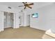 Bright bedroom with a ceiling fan, large windows, and ample closet space at 8230 Harborside Cir, Englewood, FL 34224