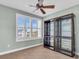 Bright bedroom with large window, ceiling fan, and display cabinet at 8230 Harborside Cir, Englewood, FL 34224