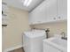 Bright laundry room with washer, dryer, and storage cabinets at 8230 Harborside Cir, Englewood, FL 34224