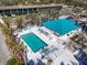 Aerial view of community pool, hot tub, and clubhouse with teal roof at 8230 Harborside Cir, Englewood, FL 34224