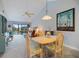 Open-concept dining area with a wooden table and chairs, seamlessly flowing into the living space with vaulted ceilings at 854 Bird Bay Way # 190, Venice, FL 34285