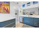 Contemporary kitchen with stainless steel dishwasher, custom blue cabinetry, and bright countertops at 854 Bird Bay Way # 190, Venice, FL 34285