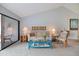 Comfortable living room with a neutral color scheme, highlighted by a striking blue coffee table and large sliding doors at 854 Bird Bay Way # 190, Venice, FL 34285
