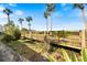 A picturesque wooden walkway leads through lush greenery and tall palm trees to the beach at 854 Bird Bay Way # 190, Venice, FL 34285