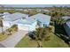 An aerial view of light blue house with a driveway, surrounded by green trees and other colorful houses at 8817 Conch Ave, Placida, FL 33946