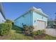 The side of a light blue house with a garage, surrounded by greenery, creating a serene view at 8817 Conch Ave, Placida, FL 33946