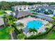 Aerial view of a community pool with lounge seating, palm trees, and a covered outdoor lounge area at 8955 Milestone Dr, Sarasota, FL 34238