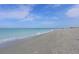 Expansive beach view with couple walking along the shore at 1000 Tarpon Center Dr # 601, Venice, FL 34285