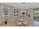 Bright dining room with glass table, chandelier, and view of backyard at 10117 Colubrina Dr, Venice, FL 34293