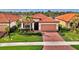 Single-story home with tile roof, brick driveway and lush landscaping at 10117 Colubrina Dr, Venice, FL 34293