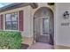 Front entrance with decorative screen door, red shutters, and brick walkway at 10117 Colubrina Dr, Venice, FL 34293