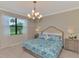 Main bedroom with king-size bed, stylish bedding and large window with natural light at 10117 Colubrina Dr, Venice, FL 34293