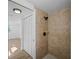 A bathroom has a tile shower and wooden look floors, with closet doors outside shower at 1023 Hope St, Venice, FL 34285