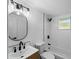 Modern bathroom features white subway tiles, black fixtures, new toilet, vanity, and mirror at 1023 Hope St, Venice, FL 34285