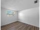 Bright, empty bedroom with wood-look flooring and natural light from window at 1023 Hope St, Venice, FL 34285