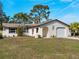 Inviting single-Gathering home showcasing lush lawn, arched entry, and attached garage at 1023 Hope St, Venice, FL 34285