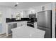 Modern kitchen with white cabinets, stainless steel appliances, black backsplash, and a center island at 1023 Hope St, Venice, FL 34285