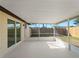 Screened patio with slider door offering view of the fenced backyard, lawn, and trees at 1023 Hope St, Venice, FL 34285