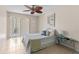 Bright bedroom with stylish decor, tile floor, and sliding glass door to outdoor balcony at 104 Capri Isles Blvd # 107, Venice, FL 34292