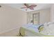 Bedroom featuring sliding glass doors to a balcony and a large decorative fan at 104 Capri Isles Blvd # 107, Venice, FL 34292