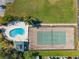 Overhead view of a pool and tennis court provides leisure activities and recreational opportunities for residents at 104 Capri Isles Blvd # 107, Venice, FL 34292