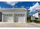 Two-car garage with white doors and concrete driveway, offering convenience and ample parking at 1041 Capri Isles Blvd # 119, Venice, FL 34292