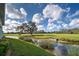 Picturesque view of the golf course, showcasing lush greenery, mature trees, and a serene water feature at 1041 Capri Isles Blvd # 119, Venice, FL 34292