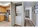 Hallway next to kitchen featuring a stacked washer and dryer closet and access to the front door at 1041 Capri Isles Blvd # 119, Venice, FL 34292