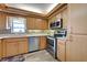 Well-lit kitchen featuring stainless steel appliances, mosaic backsplash, and wood-look flooring at 1041 Capri Isles Blvd # 119, Venice, FL 34292