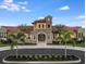 Front of community clubhouse with beautiful stonework, stucco, and lush tropical landscaping at 11903 Alessandro Ln, Venice, FL 34293