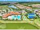 Expansive aerial shot featuring the community pool, tennis courts, and surrounding neighborhood with a lake at 11903 Alessandro Ln, Venice, FL 34293