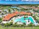 Aerial view of a community pool, clubhouse, and lush landscaping in a residential neighborhood at 11903 Alessandro Ln, Venice, FL 34293