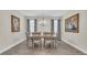 Formal dining room with wood flooring, elegant chandelier, and windows with blinds and curtains at 11903 Alessandro Ln, Venice, FL 34293