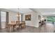 Dining room with wood floors, chandelier, and access to the kitchen and living areas at 11903 Alessandro Ln, Venice, FL 34293