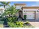 Charming home with a two-car garage, brick driveway, manicured lawn, and lush landscaping at 11903 Alessandro Ln, Venice, FL 34293