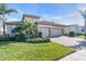 Charming home with a two-car garage, brick driveway, manicured lawn, and lush landscaping at 11903 Alessandro Ln, Venice, FL 34293