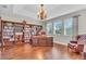 Bright office boasting rich wood flooring, an ornate light fixture, and a large bookcase at 11903 Alessandro Ln, Venice, FL 34293