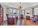 Home office featuring an ornate chandelier, wood floors, built-in bookcase, and desk at 11903 Alessandro Ln, Venice, FL 34293