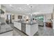 Bright kitchen with granite countertops, an island with pendant lighting, and stainless steel appliances at 11903 Alessandro Ln, Venice, FL 34293